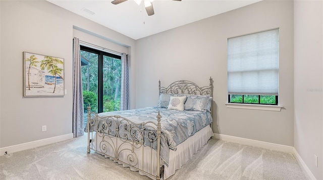 bedroom with light carpet, a ceiling fan, visible vents, and baseboards