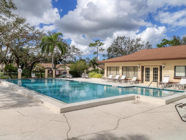 view of pool with french doors and a patio