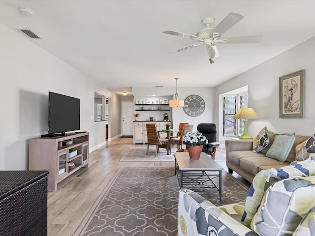 living room featuring hardwood / wood-style floors and ceiling fan