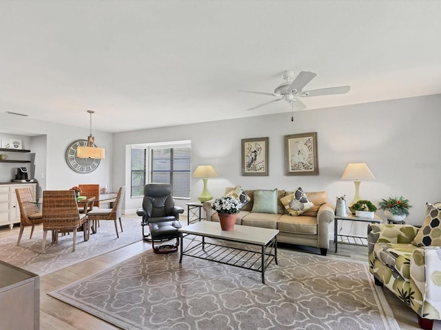 living room featuring hardwood / wood-style floors and ceiling fan