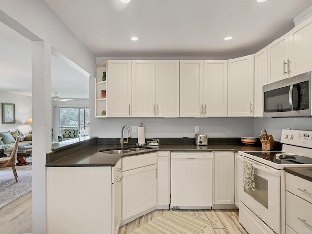 kitchen featuring white appliances, sink, light wood-type flooring, and white cabinets