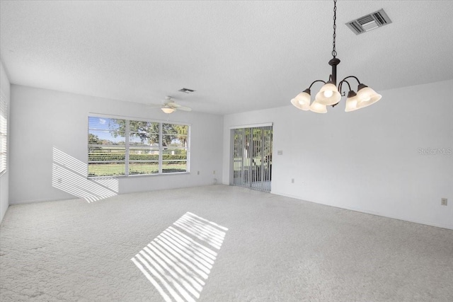 carpeted spare room featuring a textured ceiling and ceiling fan with notable chandelier