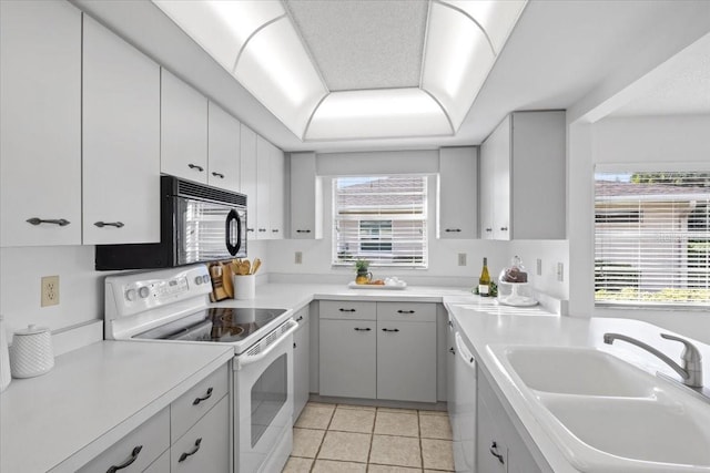 kitchen featuring white appliances, white cabinetry, sink, and plenty of natural light