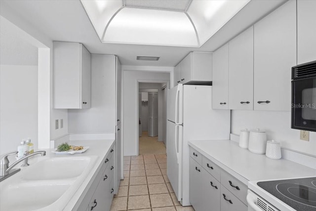 kitchen featuring light tile patterned flooring, white cabinetry, and sink