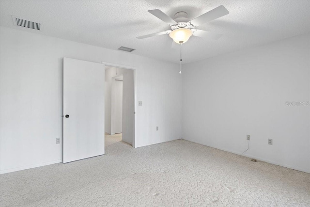 carpeted empty room featuring a textured ceiling and ceiling fan