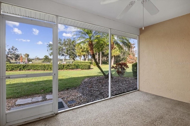 unfurnished sunroom featuring ceiling fan