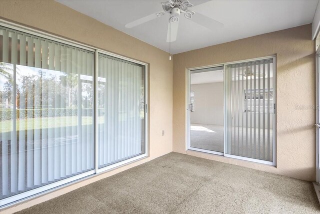 unfurnished sunroom featuring ceiling fan