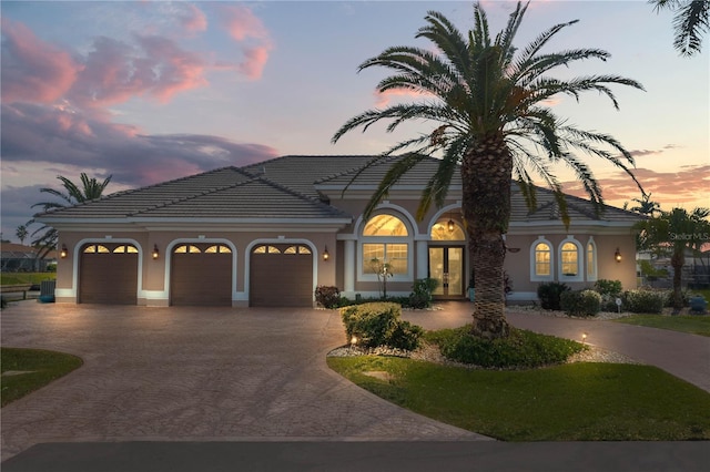 mediterranean / spanish house with central air condition unit and a garage