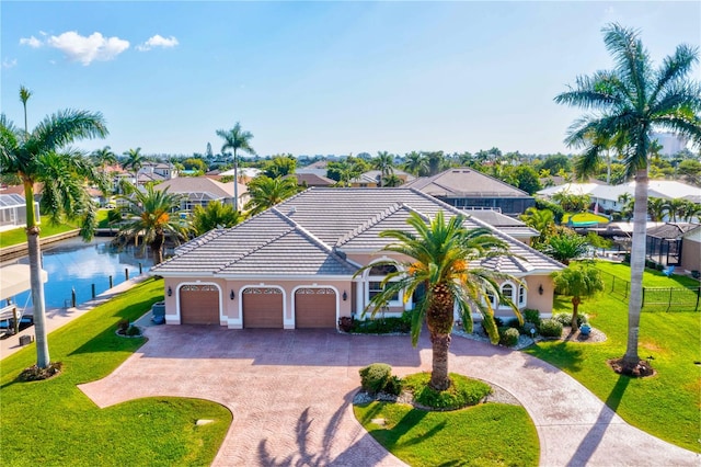 view of front of property with a garage, a water view, and a front lawn