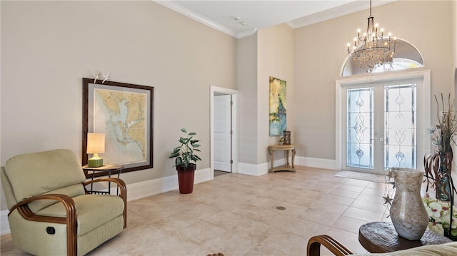 entryway featuring a towering ceiling, french doors, a chandelier, and crown molding