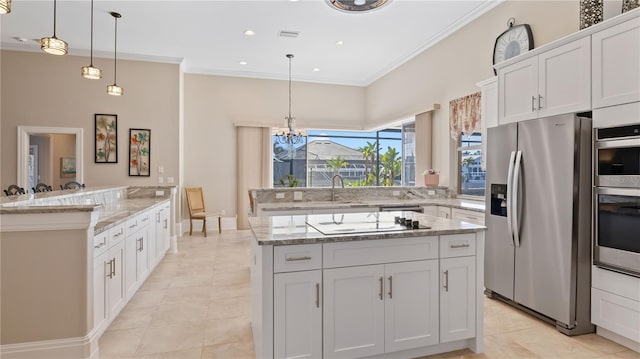 kitchen featuring stainless steel appliances, hanging light fixtures, white cabinetry, and a center island