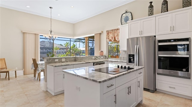 kitchen featuring ornamental molding, decorative backsplash, appliances with stainless steel finishes, and a center island