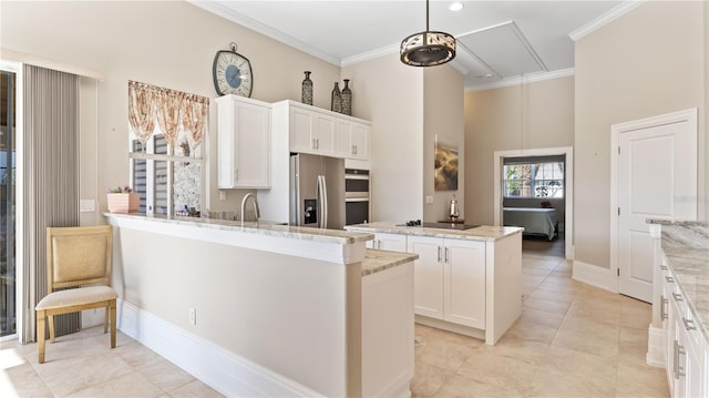 kitchen featuring white cabinets, kitchen peninsula, a kitchen island with sink, light stone countertops, and appliances with stainless steel finishes