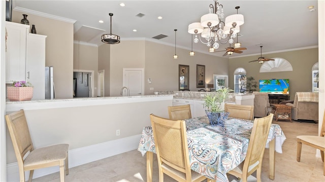 dining space featuring light tile patterned flooring, ornamental molding, and ceiling fan with notable chandelier