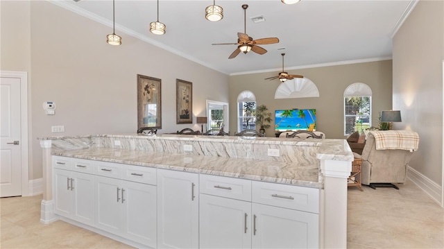 kitchen with white cabinets, pendant lighting, ceiling fan, and crown molding