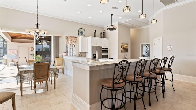 kitchen featuring white cabinets, a breakfast bar, decorative light fixtures, and appliances with stainless steel finishes