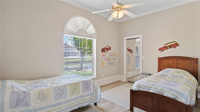 bedroom with light wood-type flooring, ceiling fan, and crown molding