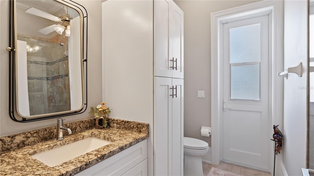 bathroom featuring toilet, vanity, an enclosed shower, and ceiling fan