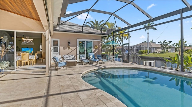 view of pool with a lanai, outdoor lounge area, ceiling fan, and a patio