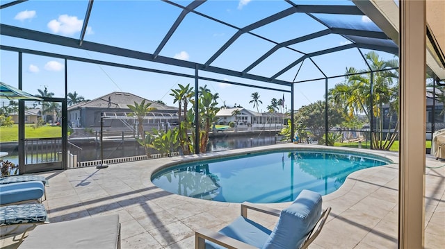 view of pool with a lanai, a water view, and a patio area