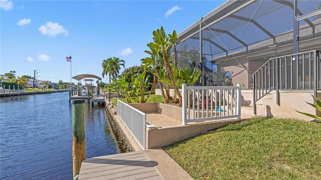 dock area with a yard, glass enclosure, and a water view