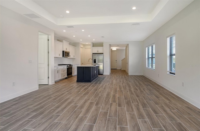 kitchen with white cabinetry, an island with sink, and appliances with stainless steel finishes