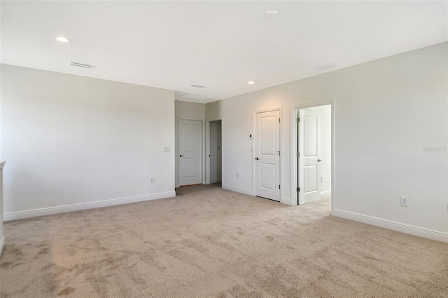 spare room featuring light colored carpet