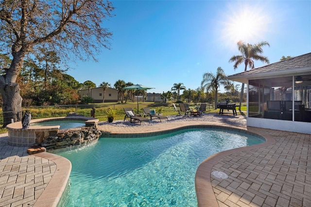 view of pool with an in ground hot tub, a patio, and a sunroom