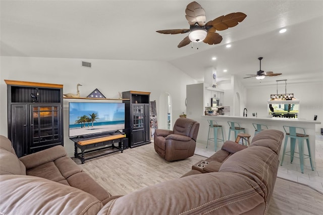 living room with lofted ceiling, light hardwood / wood-style flooring, and ceiling fan