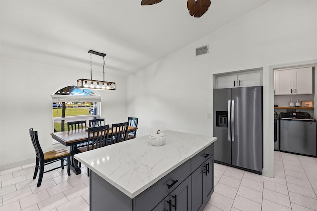 kitchen with gray cabinetry, separate washer and dryer, hanging light fixtures, stainless steel fridge, and lofted ceiling