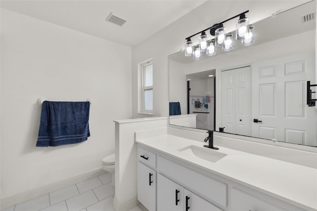 bathroom featuring vanity, toilet, and tile patterned flooring