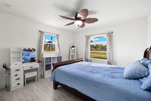 bedroom featuring multiple windows, light hardwood / wood-style floors, and ceiling fan