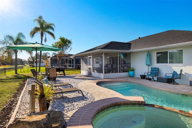 view of pool featuring ceiling fan, a sunroom, a patio area, an in ground hot tub, and a lawn