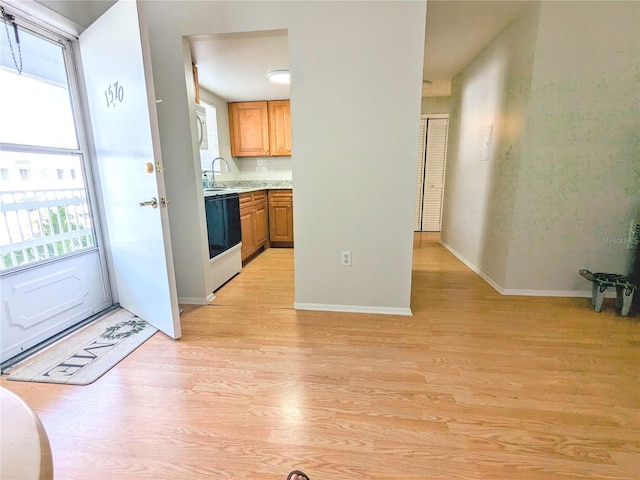 kitchen featuring tasteful backsplash, sink, light hardwood / wood-style floors, and white stove