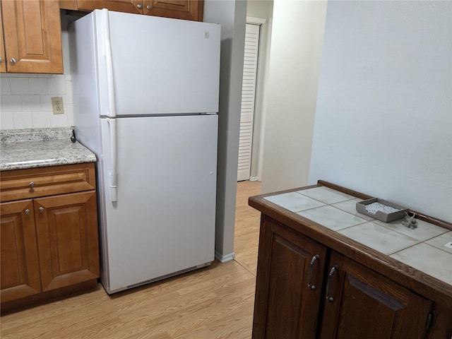 1570 Pleasant Rd Unit J-26, Bradenton, FL 34207 - kitchen featuring white refrigerator, light hardwood / wood-style floors, and backsplash