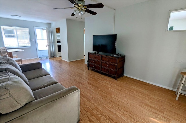 living room with light hardwood / wood-style flooring and ceiling fan