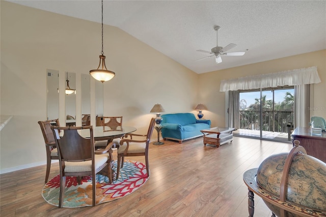 dining area with hardwood / wood-style floors, a textured ceiling, vaulted ceiling, and ceiling fan