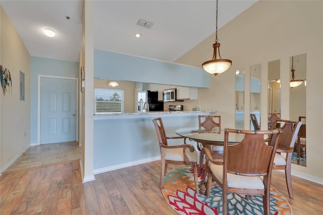 dining area featuring wood-type flooring and lofted ceiling