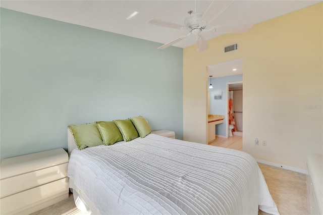 carpeted bedroom featuring ceiling fan and ensuite bathroom