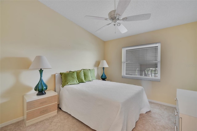 carpeted bedroom with ceiling fan and a textured ceiling