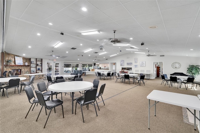 carpeted dining space featuring ceiling fan and vaulted ceiling