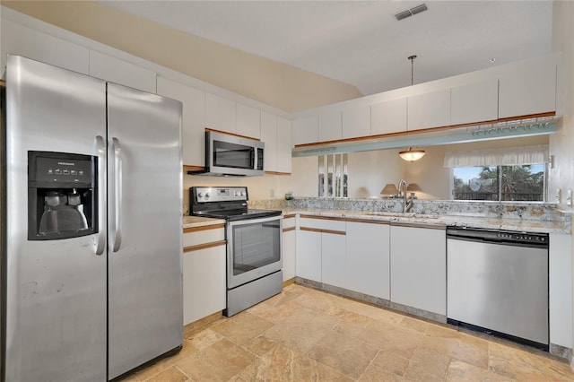 7201 29th Avenue Dr W Unit 309, Bradenton, FL 34209 - kitchen featuring appliances with stainless steel finishes, stone tile floors, lofted ceiling, and white cabinets