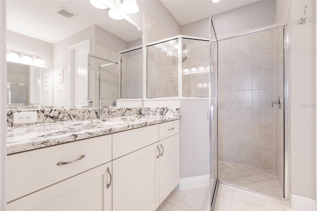 bathroom with tile patterned flooring, vanity, and walk in shower