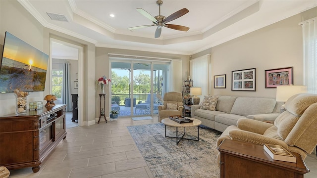 tiled living room featuring ceiling fan, a raised ceiling, and crown molding