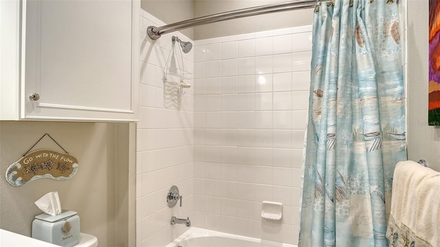 bathroom featuring shower / bath combination with curtain and toilet