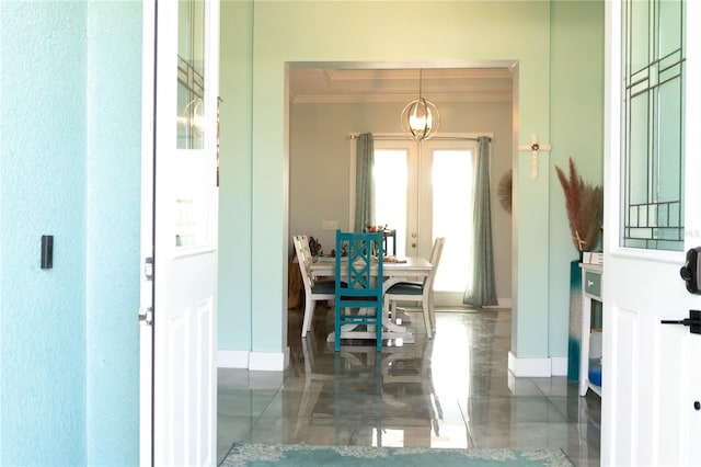 interior space with an inviting chandelier, crown molding, and french doors