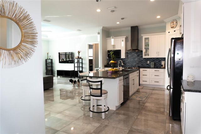 kitchen with a kitchen island with sink, wall chimney range hood, stainless steel refrigerator, and white cabinets