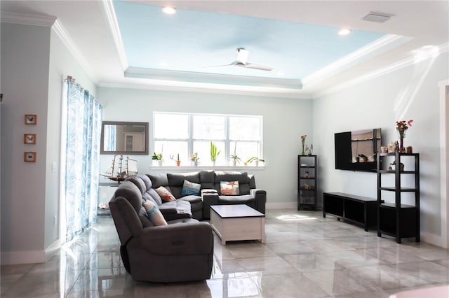 living room featuring ceiling fan, ornamental molding, and a tray ceiling