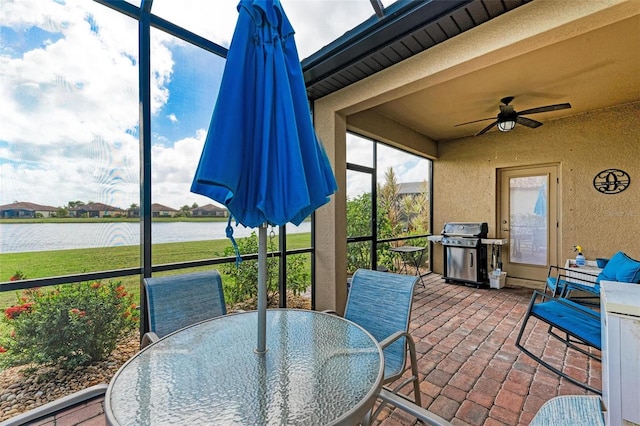 sunroom / solarium featuring a water view and ceiling fan