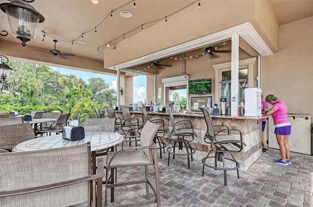 view of patio with exterior bar and ceiling fan